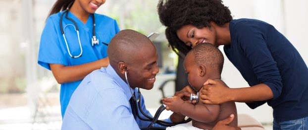 a doctor checking a baby accompanied by his mother and nurse